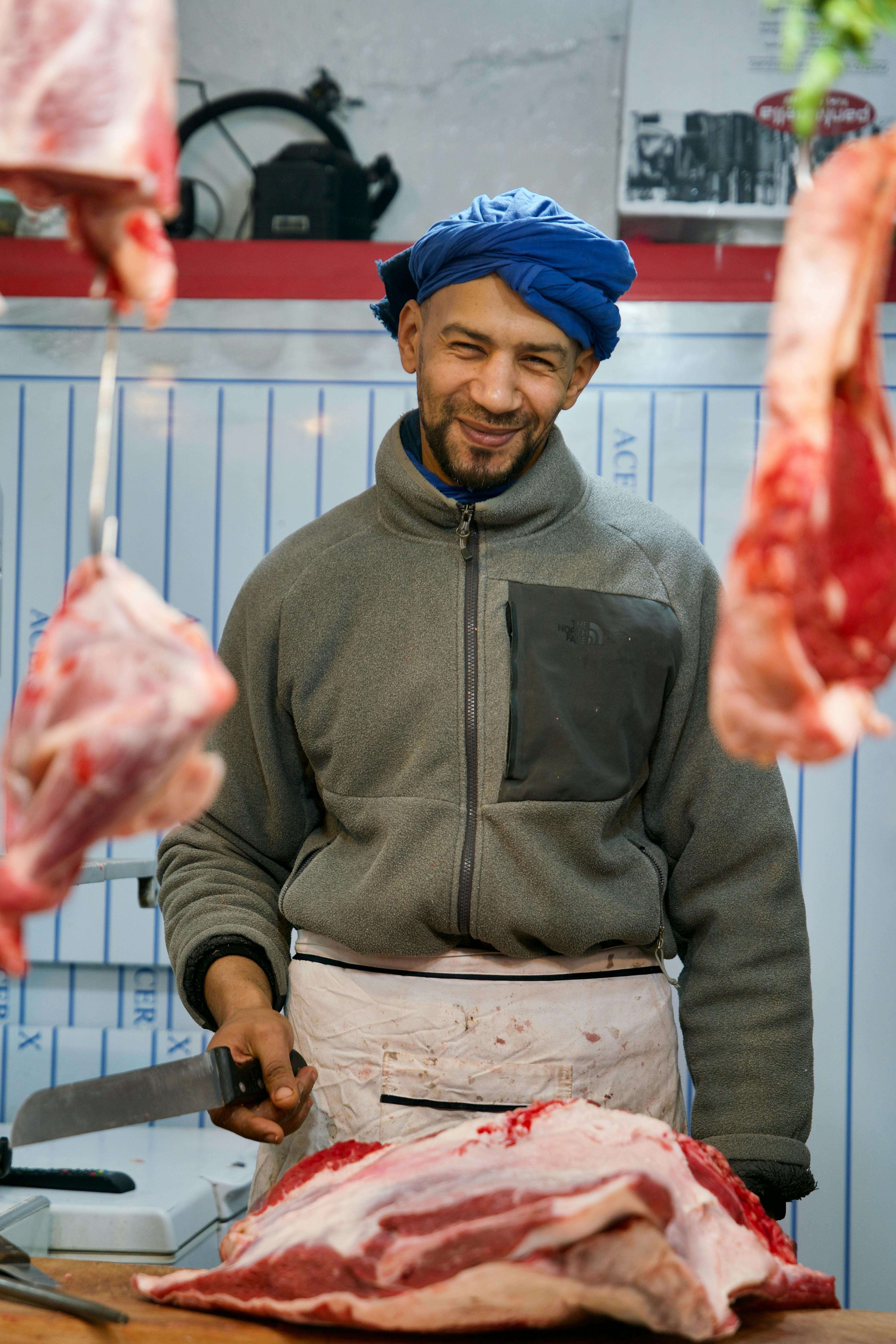 Amer at the counter — founder portrait, apron on, warm light